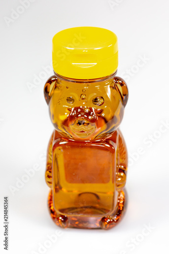 A bear shaped plastic bottle full of honey waiting to be used 