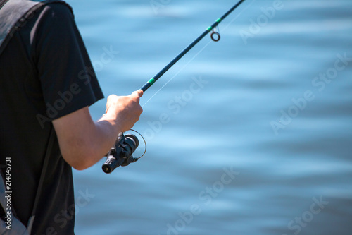 the man is fishing with a fishing rod, close up