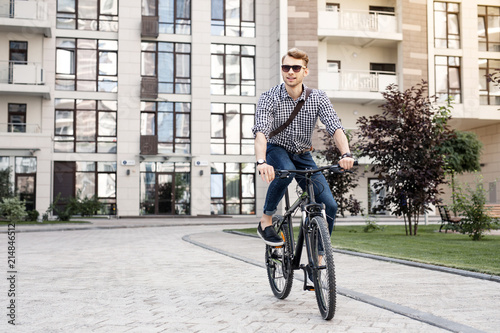 Fototapeta Naklejka Na Ścianę i Meble -  Fast bike. Positive happy man smiling while enjoying his ride on the bicycle