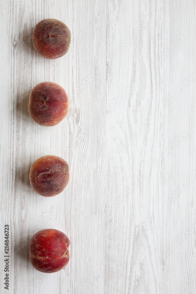 Fresh ripe peaches on white wooden background, top view. Space for text.
