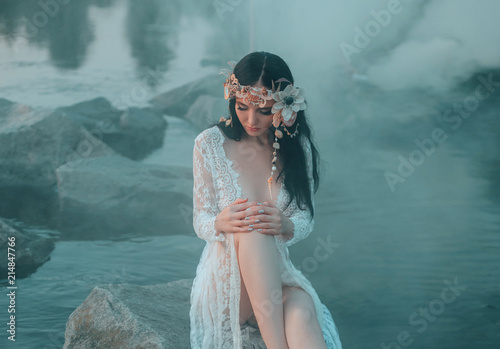 Photos A lonely mermaid, sitting on a rock in the middle of the river, which was tightened by a thick, impenetrable fog
