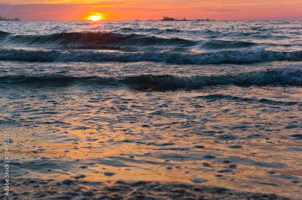 Obraz premium Sunrise in the waves of the sea. Sunset on the sea.