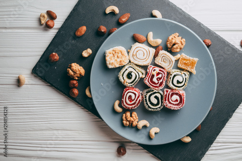 Bilde på lerret Traditional oriental sweets and nuts: hazelnuts, cashews on a white wooden background