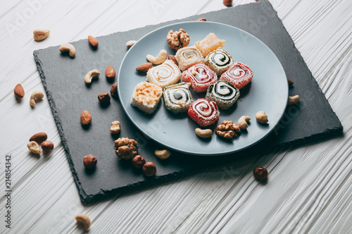 Bilde på lerret Traditional oriental sweets and nuts: hazelnuts, cashews on a white wooden background