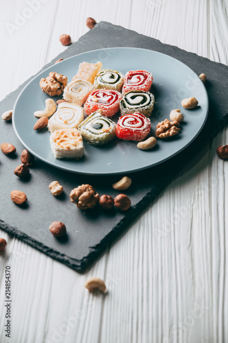 Bilde på lerret Traditional oriental sweets and nuts: hazelnuts, cashews on a white wooden background