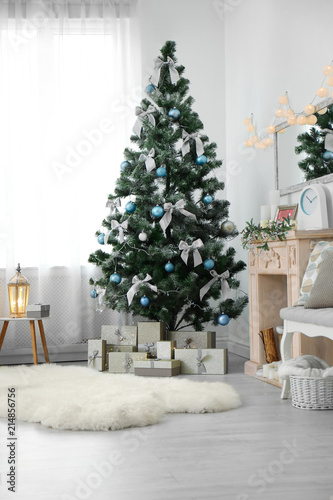 Stylish living room interior with decorated Christmas tree © New Africa
