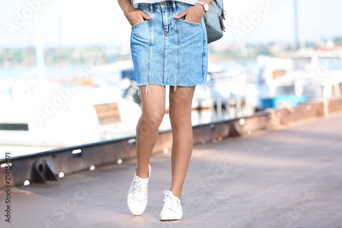 Young hipster woman in jean skirt on pier