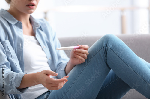 Young woman with pregnancy test at home. Gynecology