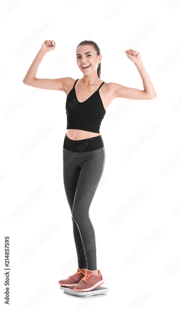 Happy young woman measuring her weight using scales on white background. Weight loss motivation Happy young woman measuring her weight using scales on white background. Weight loss motivation