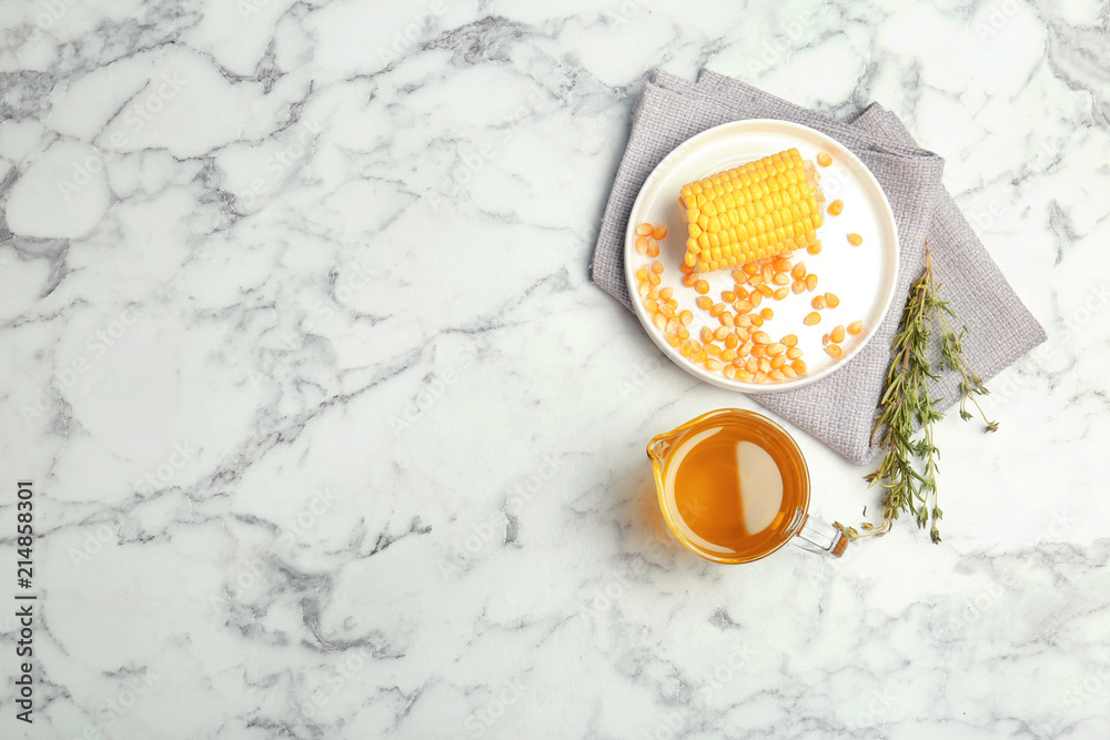 Flat lay composition with corn and jug of oil on marble background Flat lay composition with corn and jug of oil on marble background