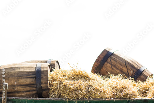 soft focus wooden barrels exterior decoration elements on cart with hay in summer bright day time on blue background with empty space for copy or text