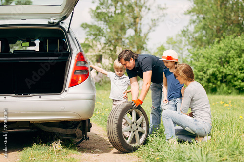 Obraz na płótnie family friendly changes the tyre on the car w salonie