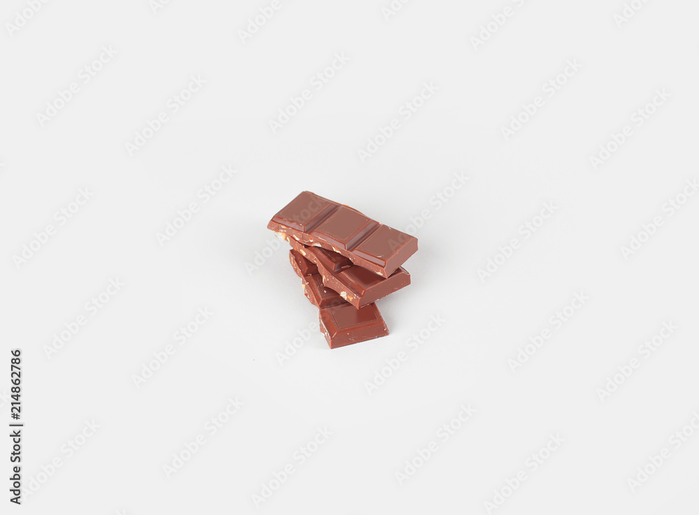 pieces of milk chocolate with nuts isolated on white pieces of milk chocolate with nuts isolated on white