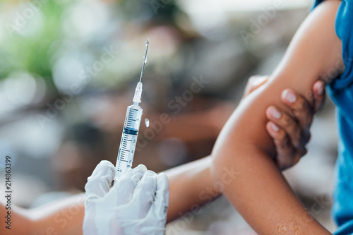 Doctor give injection to boy's arm , healthy and medical concept