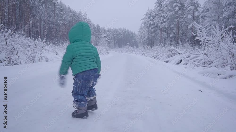 Little boy walks and playing on snowy wood, child walking on winter forest slow motion Little boy walks and playing on snowy wood, child walking on winter forest slow motion
