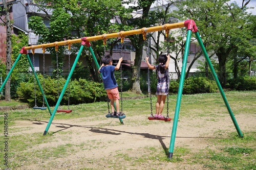 公園のブランコで遊ぶ子供