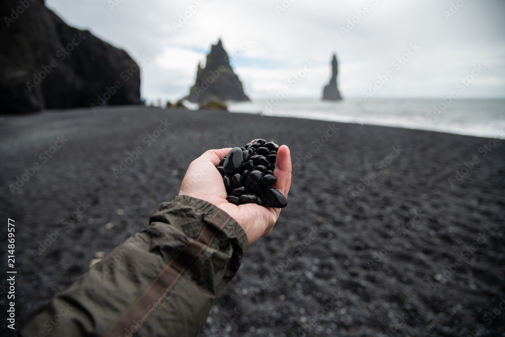 Fototapeta premium Black rocks on hand from black sand beach Reynisfjara Vik ,Iceland.