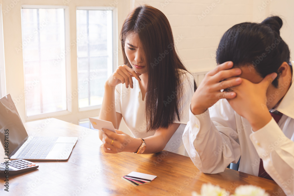 Depressed young couple having bad headache feeling stressed by lack of money to pay out debts with credit cards, family managing finances planning expenses. Depressed young couple having bad headache feeling stressed by lack of money to pay out debts with credit cards, family managing finances planning expenses.