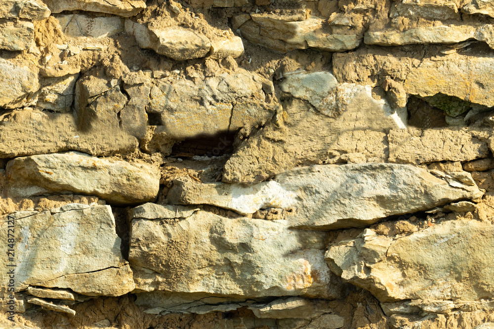 Fototapeta premium Background texture, stone buds, limestone, basalt, cobblestone, granite, pebbles, slate, sandstone laid the wall or in the fence close up for inscriptions or advertisements. Seamless texture