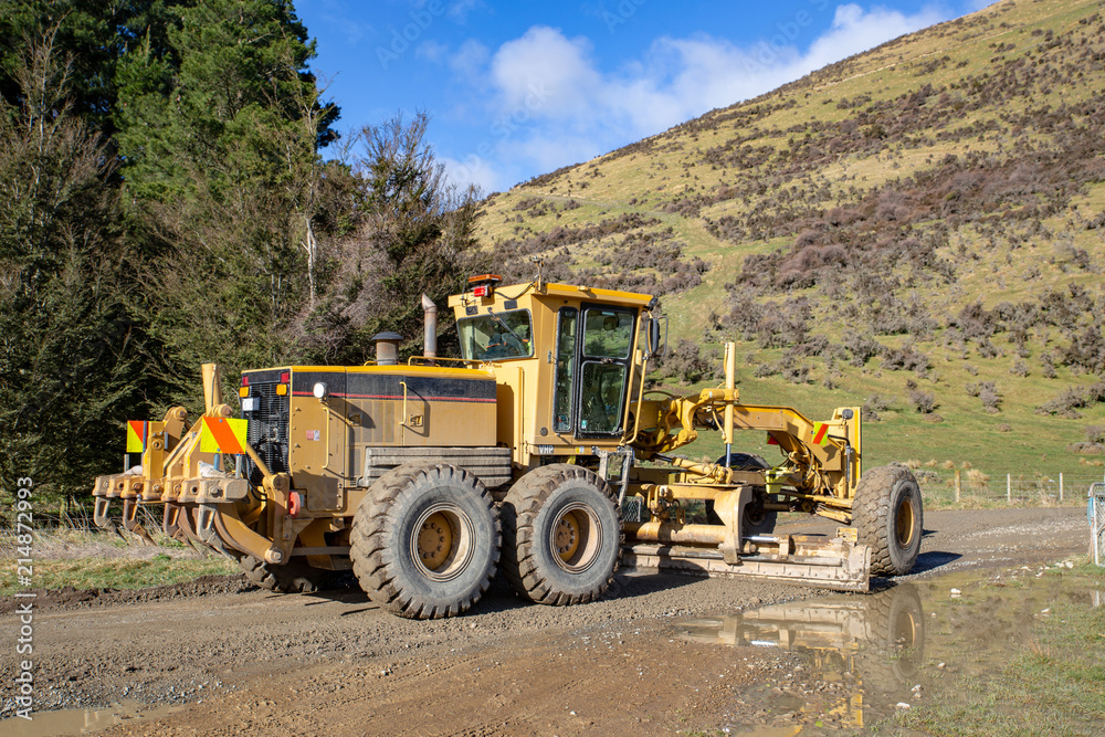 A grader levels out a rural forestry road A grader levels out a rural forestry road