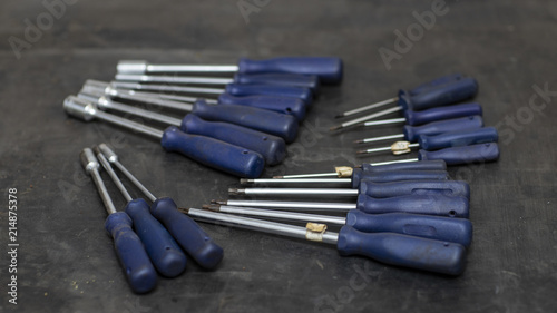 Different types of screwdrivers on the workbench, blurred background 