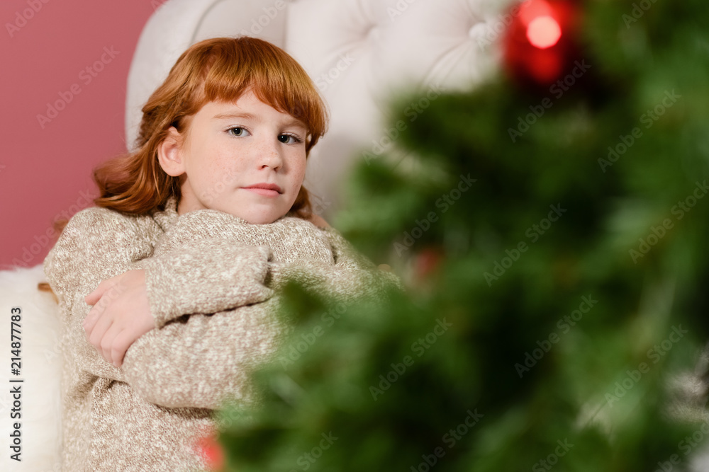 the girl in the next to the white fireplace, decorate a Christmas tree with toys the girl in the next to the white fireplace, decorate a Christmas tree with toys