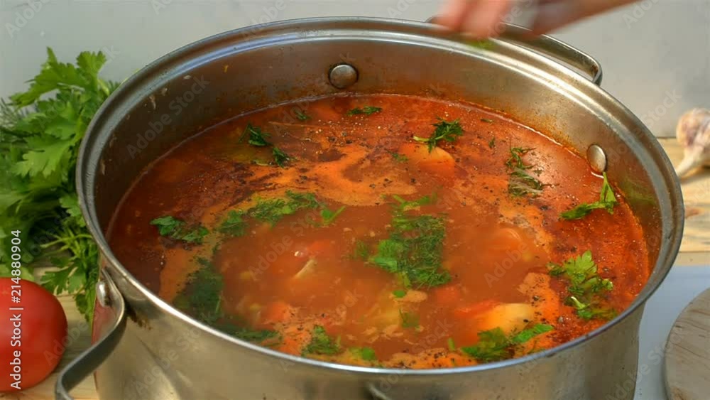 Pot with a homemade appetizing and tasty borsch. Red beetroot vegetable soup, boiling in a saucepan. Ukrainian and russian traditional red soup - borscht or borsch.