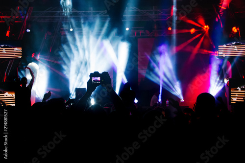 Silhouettes of concert crowd in front of bright stage lights