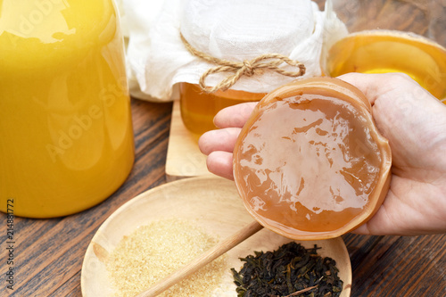 Obraz na płótnie Scoby, Hand holding tea mushroom with kombucha tea, Healthy fermented food, Probiotic nutrition drink for good balance digestive system. w salonie