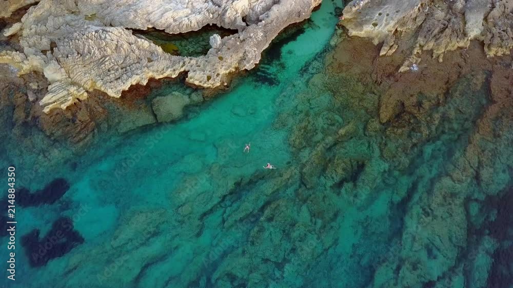 Aerial of People Swimming in Turquoise Sea at Rocky Coastline Aerial of People Swimming in Turquoise Sea at Rocky Coastline