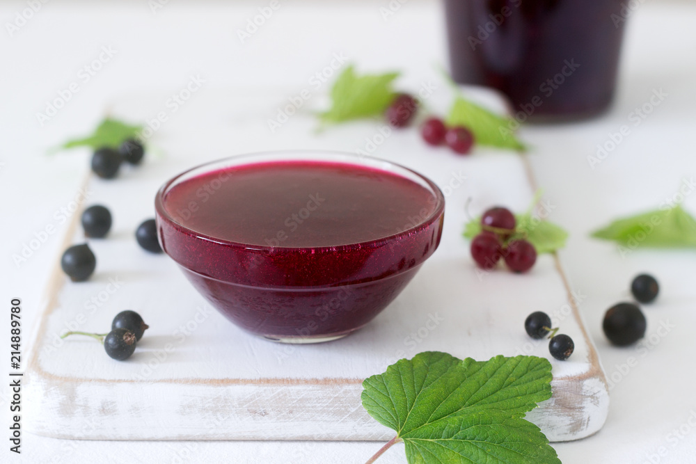 Jam or marmalade of black and red currant and currant berries on a light background. Jam or marmalade of black and red currant and currant berries on a light background.