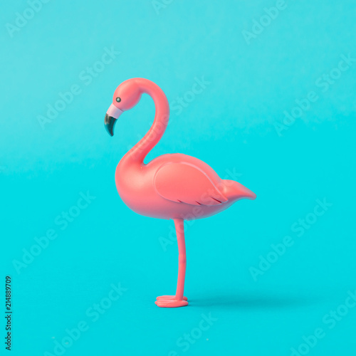 Pink Flamingo toy on pastel blue background. Minimal summer concept.