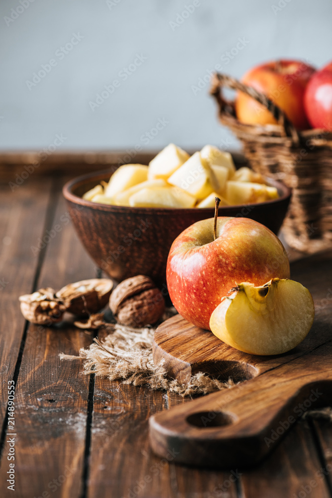 close up view of cut and wholesome apples on cutting board on dark wooden surface