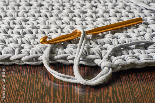 hook for knitting in a loop against the backdrop of a knitted carpet