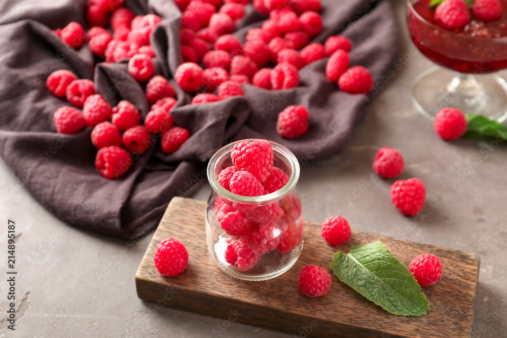 Glass jar with fresh ripe raspberries on table Glass jar with fresh ripe raspberries on table