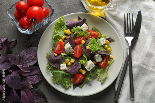 Tasty vegetable salad with feta cheese on grey background