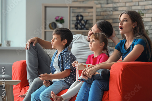 Family watching TV on sofa ...