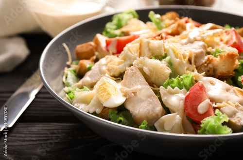 Tasty Caesar salad with pasta on plate, closeup