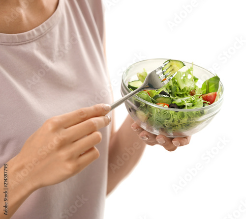 Young woman eating fresh vegetable salad at home, closeup