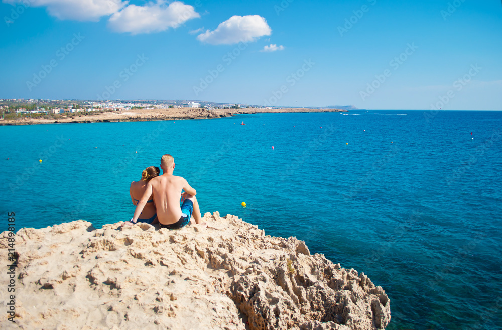 Romantic couple sitting together on a rock Romantic couple sitting together on a rock