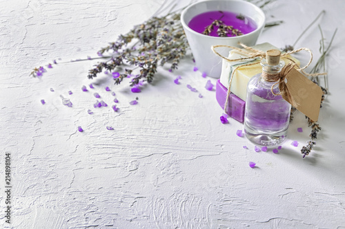 Fototapeta Naklejka Na Ścianę i Meble -  Bottle of essential oil with lavender and soap on light table