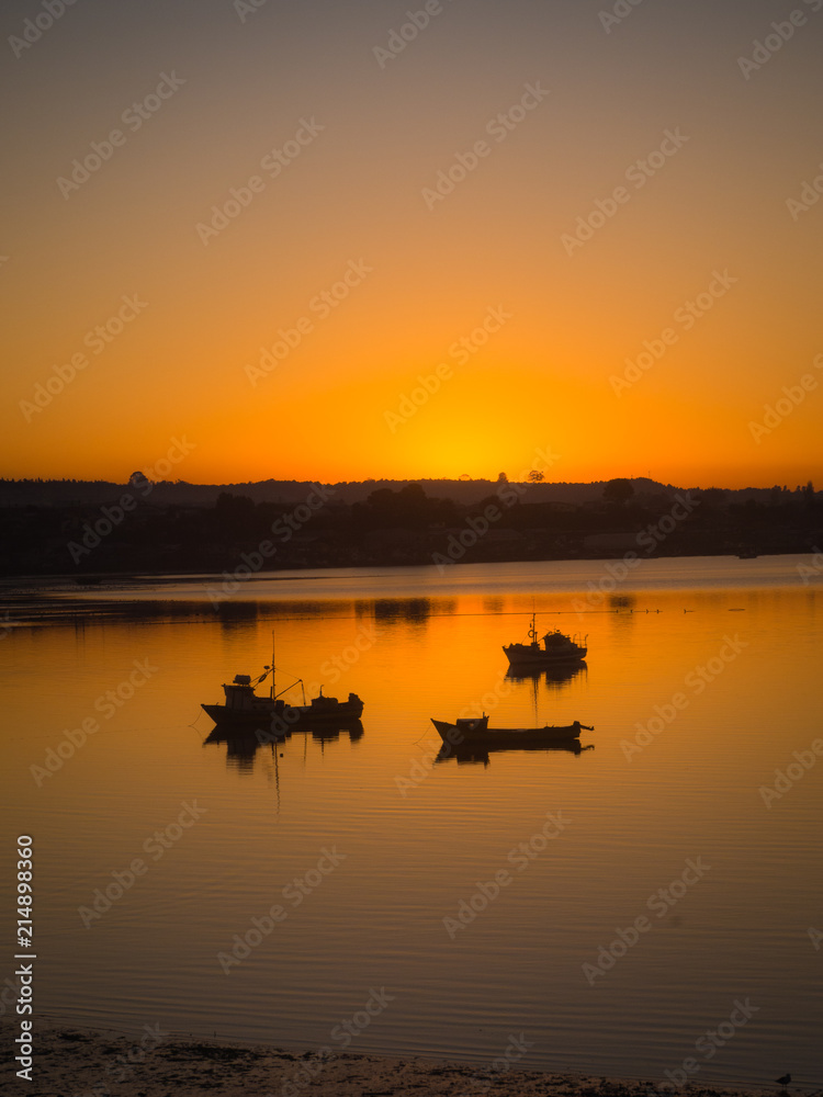 Sunrise at quellón channel with fishing boats