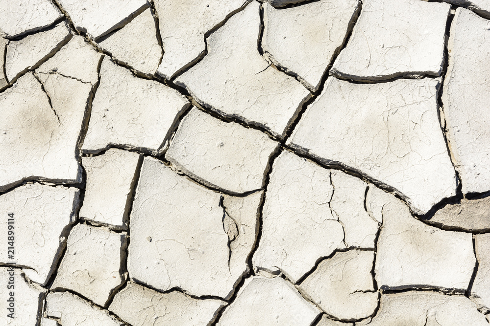 Obraz premium Overhead view of the patterns of a cracked dry grey earth.