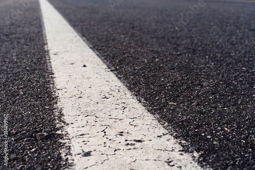 Black asphalt road and white dividing lines