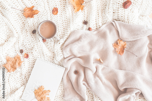 Autumn composition. Cup of coffee, women fashion sweater, dried leaves, plaid, notebook. Autumn, fall concept. Flat lay, top view, copy space