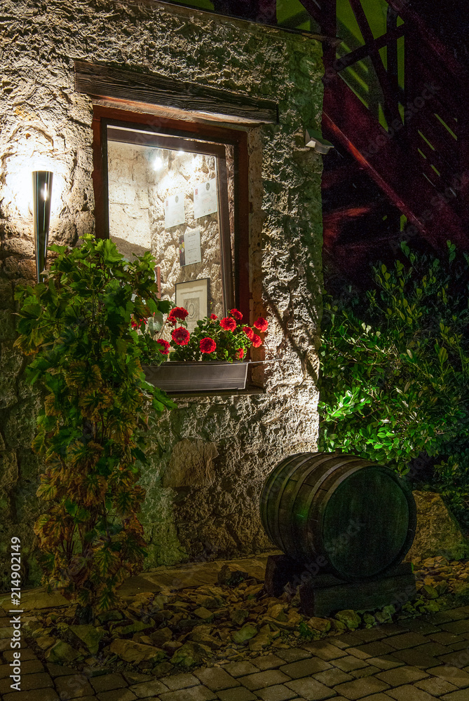 Naklejka premium An old wooden barrel under the window, evening