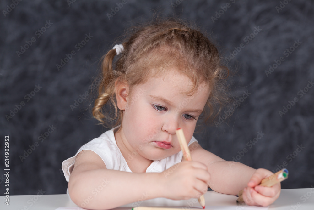 Little girl draws with pencils, portrait on background of school board Little girl draws with pencils, portrait on background of school board