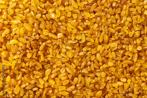 Macro image of bulgur grains as natural vegan food background. Top view