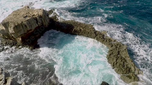 A shot with a gimbal over a blue hole and crashing waves. photo