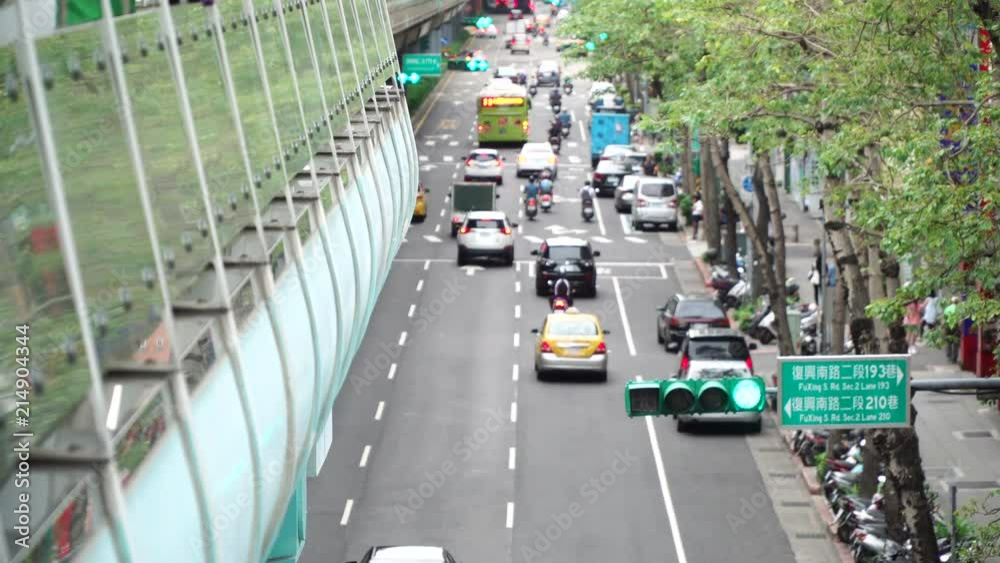 Many cars and motorbikes are bustling at a large intersection during the daytime in a busy city of Taipei, Taiwan. Long shot. Many cars and motorbikes are bustling at a large intersection during the daytime in a busy city of Taipei, Taiwan. Long shot.